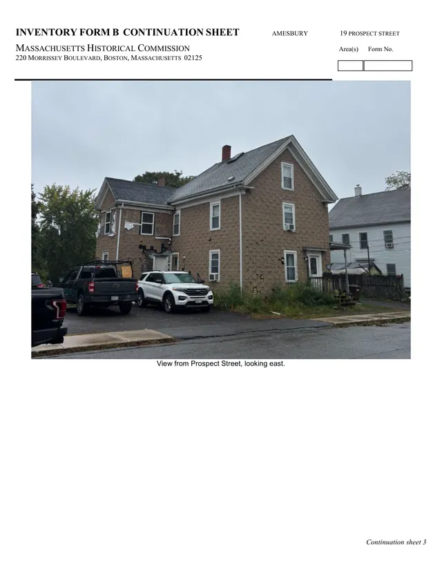 Street-level photo of the existing building at 19 Prospect Street, viewed from Prospect Street looking east. The image shows the two-story house and surrounding parking area, with neighboring houses visible at the right and left edges.