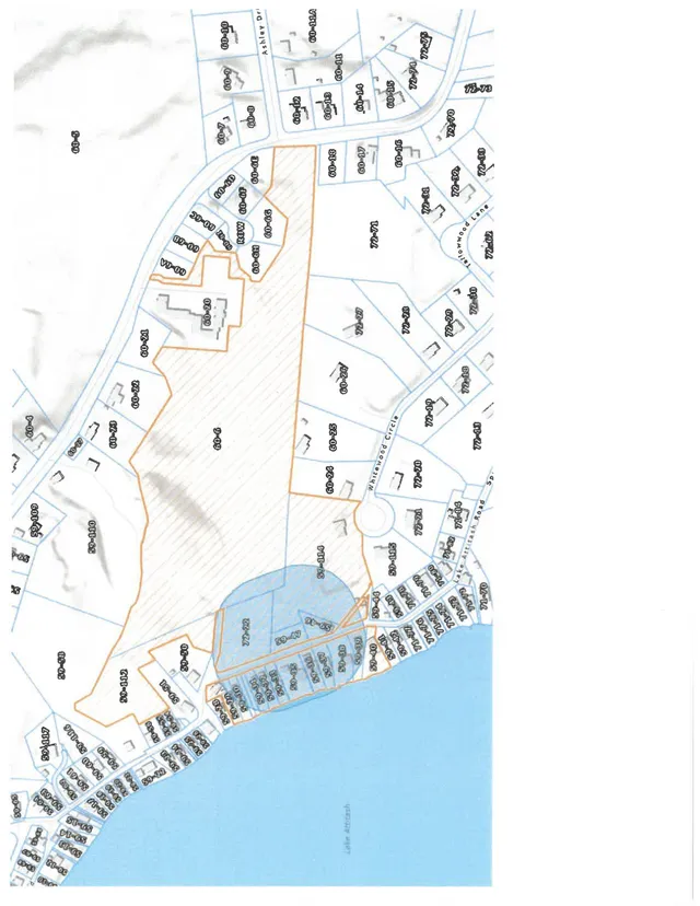 A parcel and abutters map showing lot boundaries, parcel numbers, building footprints, and the outline of the project area near Lake Attitash and surrounding roads. The highlighted property appears in orange with nearby parcels labeled around it.