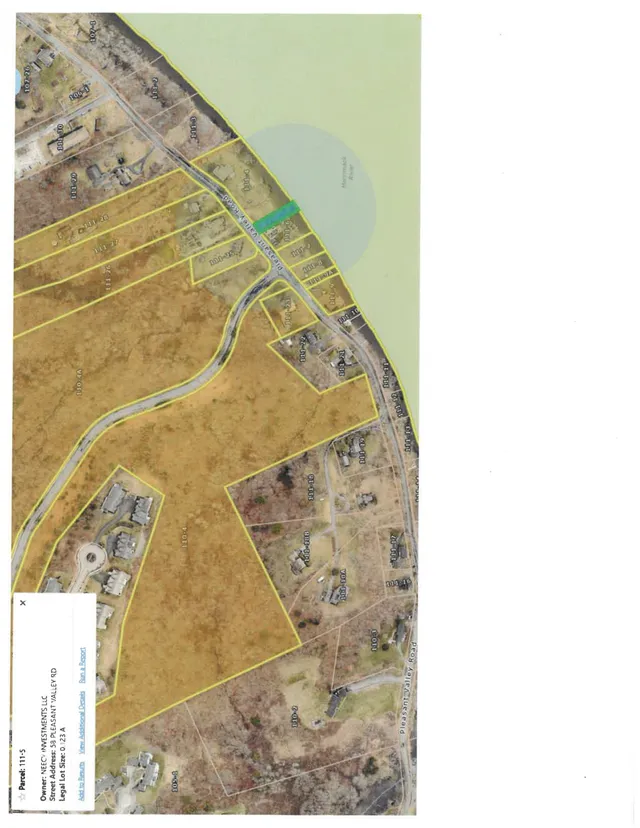 A parcel map overlaid on aerial imagery showing lots and property boundaries around Pleasant Valley Road, with one highlighted parcel near the road and nearby homes and open land visible.