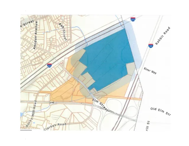 A colored zoning or parcel context map showing the area around Elm Street, Rabbit Road, I-495, Ash Street, and nearby streets and parcels. A large blue-shaded area occupies the center of the map, with surrounding street network and labels.