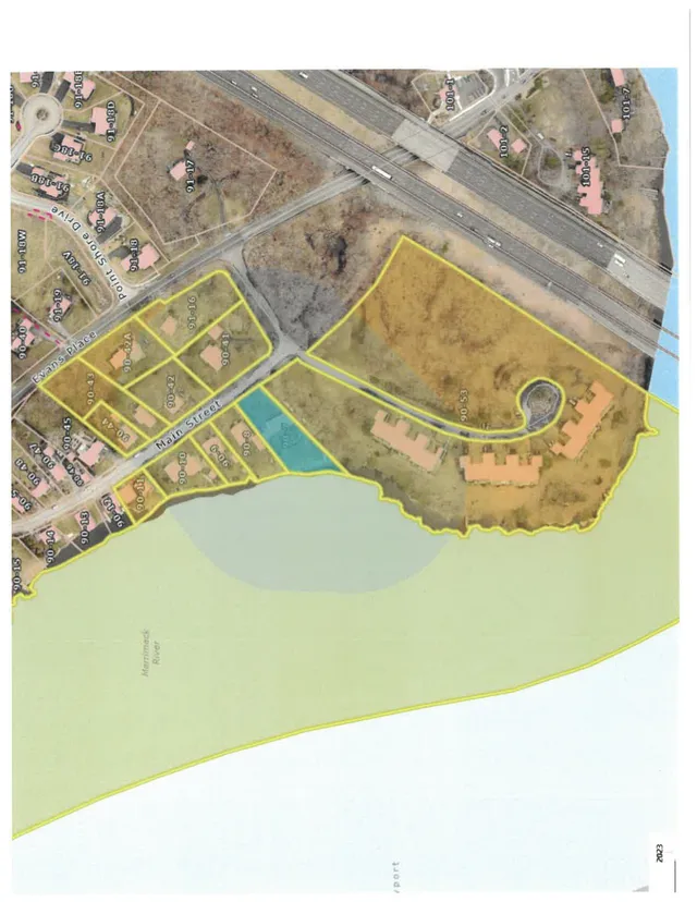 Aerial orthophoto map showing the 501 Main St area and surrounding parcels, with property boundaries outlined in yellow and nearby roads, buildings, and the Merrimack River visible.