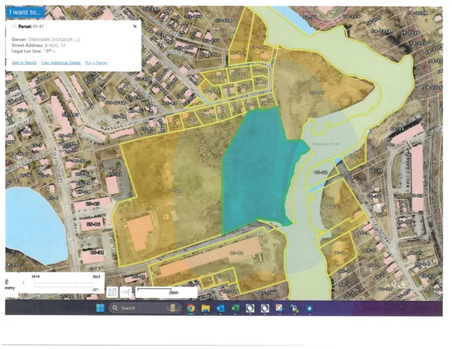 A GIS parcel map over an aerial basemap showing the 8 Noel St parcel outlined and highlighted among surrounding lots, roads, and wetlands/river features. A pop-up identifies Parcel 65-87 at 8 Noel St.