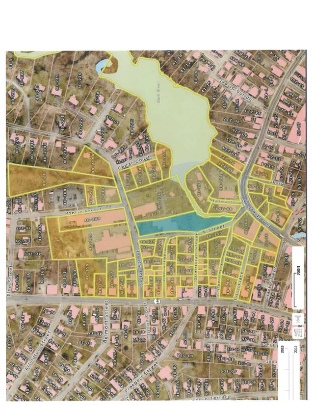 A parcel map over aerial imagery showing property lines, lot numbers, and street names around Cedar Street and nearby neighborhoods in Amesbury, with a large water body at the center. The subject is a contextual assessor-style map rather than a project rendering or site plan.