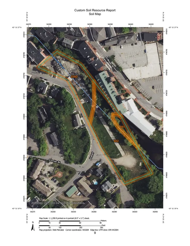 Custom Soil Resource Report soil map over an aerial basemap showing the project area around Powwow River, Water St, Valley, and Currier St, with highlighted soil units and parcel boundaries. The mapped corridor follows the river and adjacent developed blocks in downtown Amesbury.