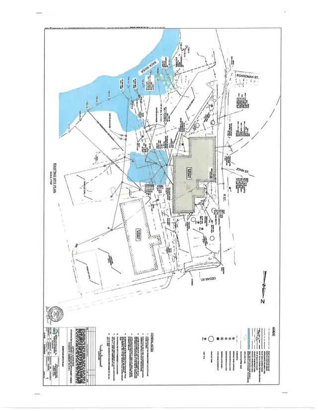Existing site plan showing property boundaries, adjacent streets, buildings, and wetland or water areas around Cedar Street, John Street, Boardman Street, and Back River. The sheet includes plan notes, legend, and title block information.