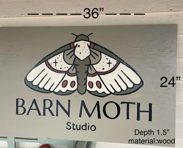 Photo of a proposed sign design board for "BARN MOTH Studio," showing a moth graphic above the business name and sign dimensions/material notes.